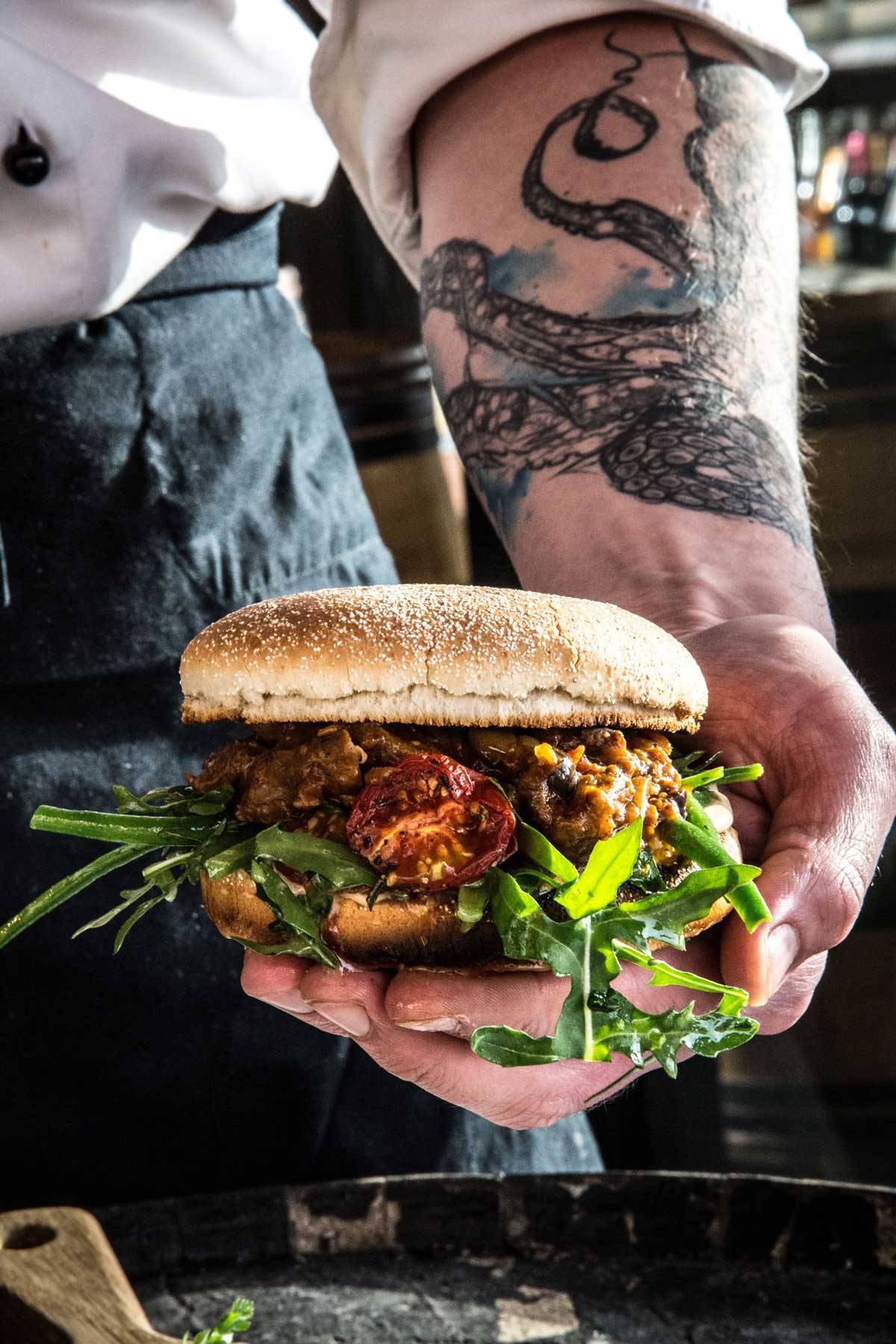 Produktbild: Fertiger Burger mit Chicken und Rucola in einer Hand