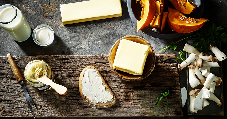 Butter Kategorie Verschiedene Butter Sorten auf einer Holzplatte